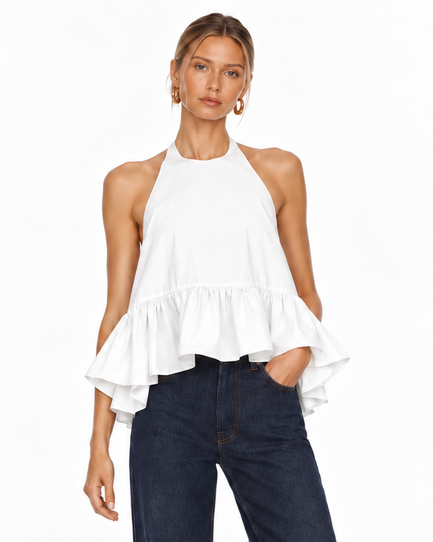 A model wearing a white sleeveless halter top with a ruffled hem and dark blue wide-leg jeans, standing against a plain white studio background.